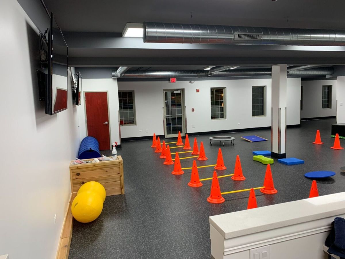 Indoor gym with orange cones setup.
