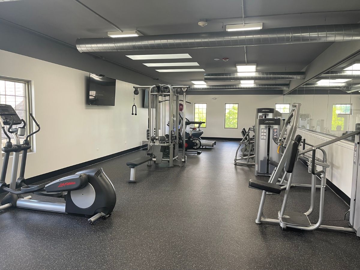 Modern gym with exercise equipment and machines.